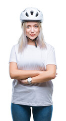 Young blonde woman wearing cyclist security helmet over isolated background happy face smiling with crossed arms looking at the camera. Positive person.