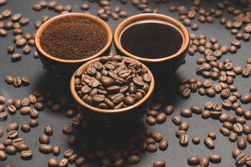 Freshly ground and prepared black coffee on a black background.