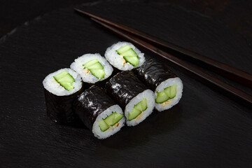 Sushi Maki rolls cucumber. Fresh hosomaki pieces with rice and nori. Close Up of delicious japanese food with sushi roll.