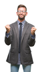 Young handsome business man over isolated background very happy and excited doing winner gesture with arms raised, smiling and screaming for success. Celebration concept.