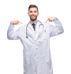 Fototapeta premium Young handsome doctor man over isolated background looking confident with smile on face, pointing oneself with fingers proud and happy.