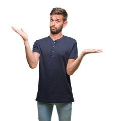 Young handsome man over isolated background clueless and confused expression with arms and hands raised. Doubt concept.