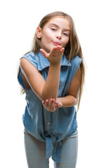 Young beautiful girl over isolated background looking at the camera blowing a kiss with hand on air being lovely and sexy. Love expression.