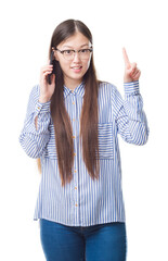 Young Chinese woman over isolated background speaking on the phone surprised with an idea or question pointing finger with happy face, number one