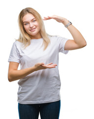 Young caucasian woman over isolated background gesturing with hands showing big and large size sign, measure symbol. Smiling looking at the camera. Measuring concept.