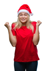 Young caucasian woman wearing christmas hat over isolated background celebrating surprised and amazed for success with arms raised and open eyes. Winner concept.