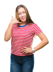 Fototapeta premium Young caucasian beautiful woman over isolated background smiling doing phone gesture with hand and fingers like talking on the telephone. Communicating concepts.
