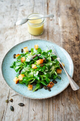 Feldsalat mit Kartoffel-Knoblauch-Dressing, gerösteten Kürbiskernen und Croûtons
