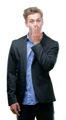 Young handsome blond business man cover mouth with hand shocked with shame for mistake, expression of fear, scared in silence, secret concept