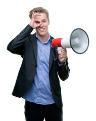 Young handsome blond man holding a megaphone with happy face smiling doing ok sign with hand on eye...