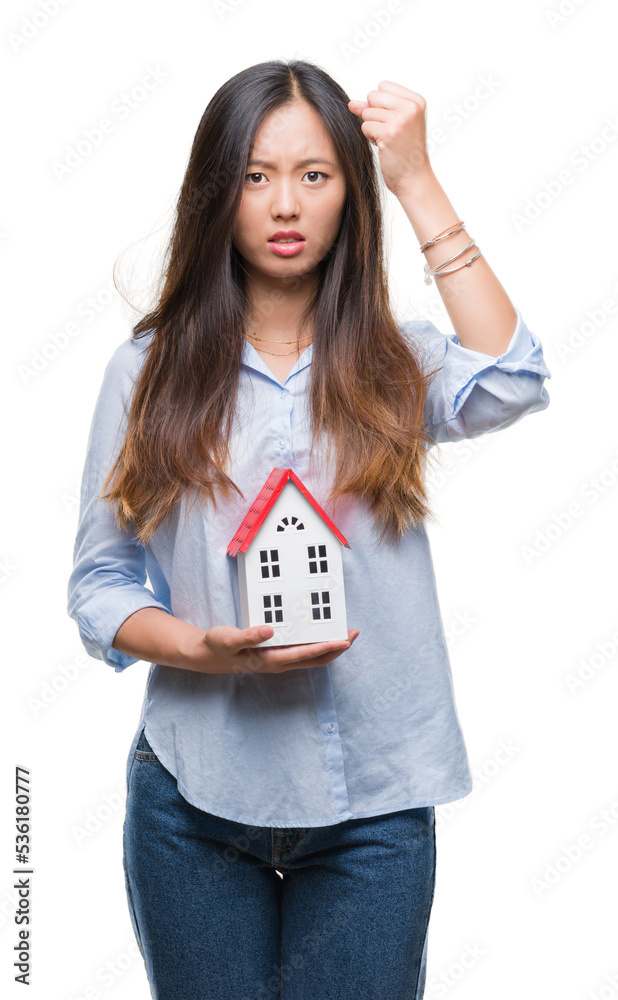 Poster Young asian woman real state agent holding house isolated background annoyed and frustrated shouting with anger, crazy and yelling with raised hand, anger concept