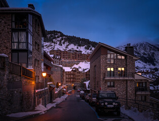 Narrow, cosy streets and modern stone houses and apartments in El Tarter village at dusk or night fall in Pyrenees mountains, Grandvalira, Andorra