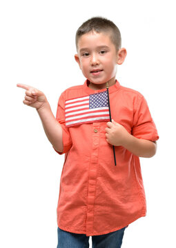 Dark Haired Little Child Holding United States Flag Very Happy Pointing With Hand And Finger To The Side