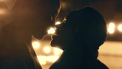Love, kiss and light with silhouette of couple on rooftop at night for romance, happy and trust in New york city. Event, hope and connection with black man and woman kissing at party together - Powered by Adobe