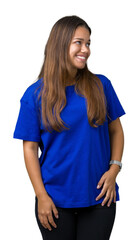 Young beautiful brunette woman wearing blue t-shirt over isolated background looking away to side with smile on face, natural expression. Laughing confident.