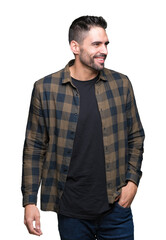Obraz premium Young handsome man over isolated background looking away to side with smile on face, natural expression. Laughing confident.