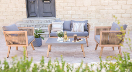Fototapeta na wymiar 3 wood and gray sofas rattan and a table made of metal in the courtyard and garden on the garden floor, comfortable sofa 