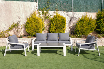 3 white sofa and table made of metal in the yard and garden on the lawn
