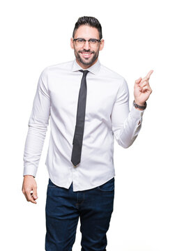 Young handsome business man wearing glasses over isolated background with a big smile on face, pointing with hand and finger to the side looking at the camera.