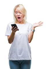 Fototapeta premium Young beautiful blonde woman using smartphone over isolated background very happy and excited, winner expression celebrating victory screaming with big smile and raised hands