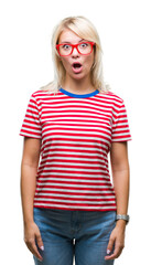 Fototapeta premium Young beautiful blonde woman wearing glasses over isolated background afraid and shocked with surprise expression, fear and excited face.