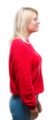 Young beautiful blonde woman wearing sweater and glasses over isolated background looking to side, relax profile pose with natural face with confident smile.