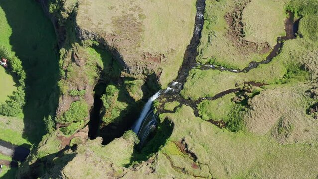 Drone Over Green Landscape Surrounding Gljufrabui Waterfall