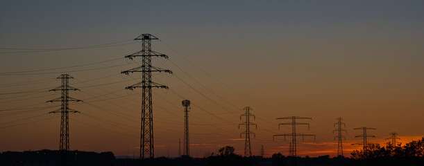 High Voltage Electricity Poles and wires on the sunset and blue sky