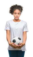 Young beautiful afro american holding soccer football ball over isolated background with a confident expression on smart face thinking serious