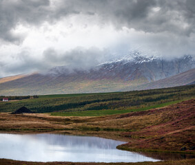 Beautiful mountain view during auto trip in Iceland. Spectacular Icelandic landscape with  scenic nature: mountains, fields, clouds, lakes, glaciers.