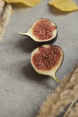 Two figs on the gray background. Autumn leaves. Gold October