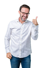 Fototapeta premium Handsome middle age elegant senior business man wearing glasses over isolated background doing happy thumbs up gesture with hand. Approving expression looking at the camera showing success.