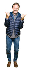 Obraz premium Middle age handsome man wearing winter coat success sign doing positive gesture with hand, thumbs up smiling and happy. Looking at the camera with cheerful expression, winner gesture.