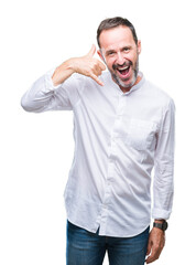 Fototapeta premium Middle age hoary senior man over isolated background smiling doing phone gesture with hand and fingers like talking on the telephone. Communicating concepts.
