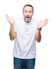 Middle age hoary senior man wearing white t-shirt over isolated background clueless and confused expression with arms and hands raised. Doubt concept.