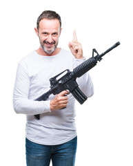 Middle age senior hoary criminal man holding gun weapon over isolated background surprised with an idea or question pointing finger with happy face, number one