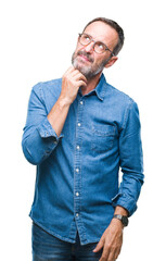 Middle age hoary senior man wearing glasses over isolated background with hand on chin thinking...
