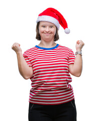 Obraz na płótnie Canvas Young adult woman with down syndrome wearing christmas hat over isolated background celebrating surprised and amazed for success with arms raised and open eyes. Winner concept.
