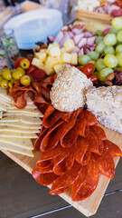 Food tray with delicious salami, sliced ​​pieces of ham, sausage, tomatoes, red berries, grapes and bread. appetizer.