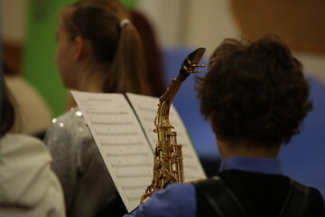 Close up of a musical instrument saxophone in a child playing in a lesson in a school orchestra.Background image of creative learning and development of children