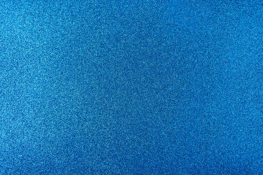 Background with sparkles. Backdrop with glitter. Shiny textured surface. Strong blue