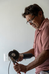 man using angle grinder, cutting a screw, friction sparks, clamping screw with tweezers...