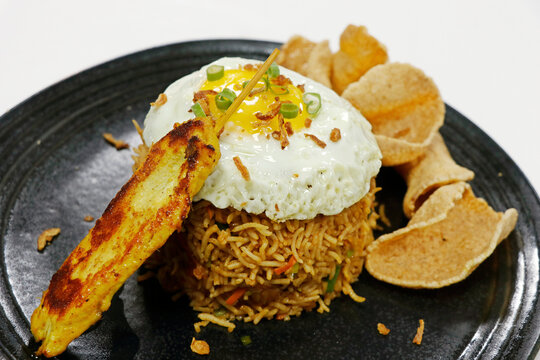Asian food speciality Nasi goreng, literally meaning fried rice in Indonesian, serve with chicken, egg, peanut sauce and shrimps