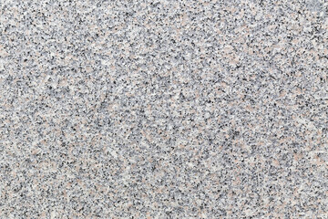 Rough granite stone, abstract, background texture from an external wall of a building. Flecks of black, grey, brown and white on an unpolished slab.