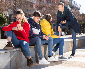 Fototapeta premium Teenagers are playing on smartphone on city street