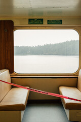 interior seats on Pacific Northwest ferry boat with red caution, danger tape blocking off seating