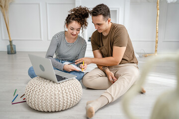 young couple man and woman having online class learn to draw on laptop