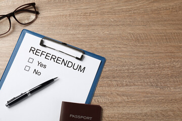 Flat lay composition with referendum ballot on wooden table. Space for text