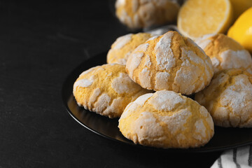 Plate with delicious lemon cookies on black table, closeup