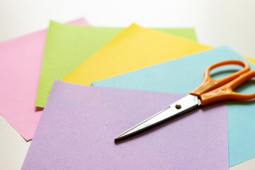 明るい色の折り紙とハサミ
